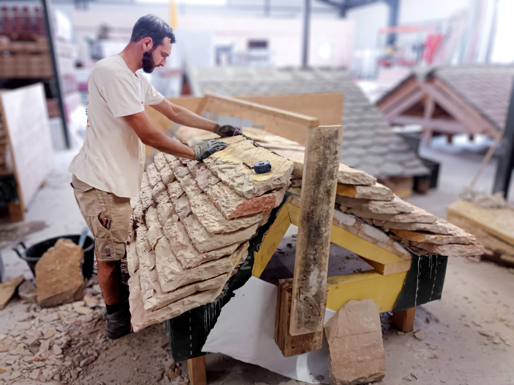 Stagiaire réalisant sa maquette en lauzes de calcaire